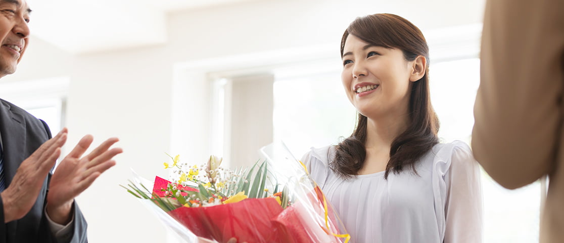 花束を受け取り笑顔の女性社員